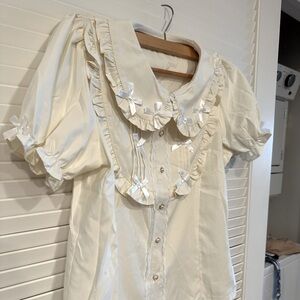 Cute top with pearl buttons and lace trim.